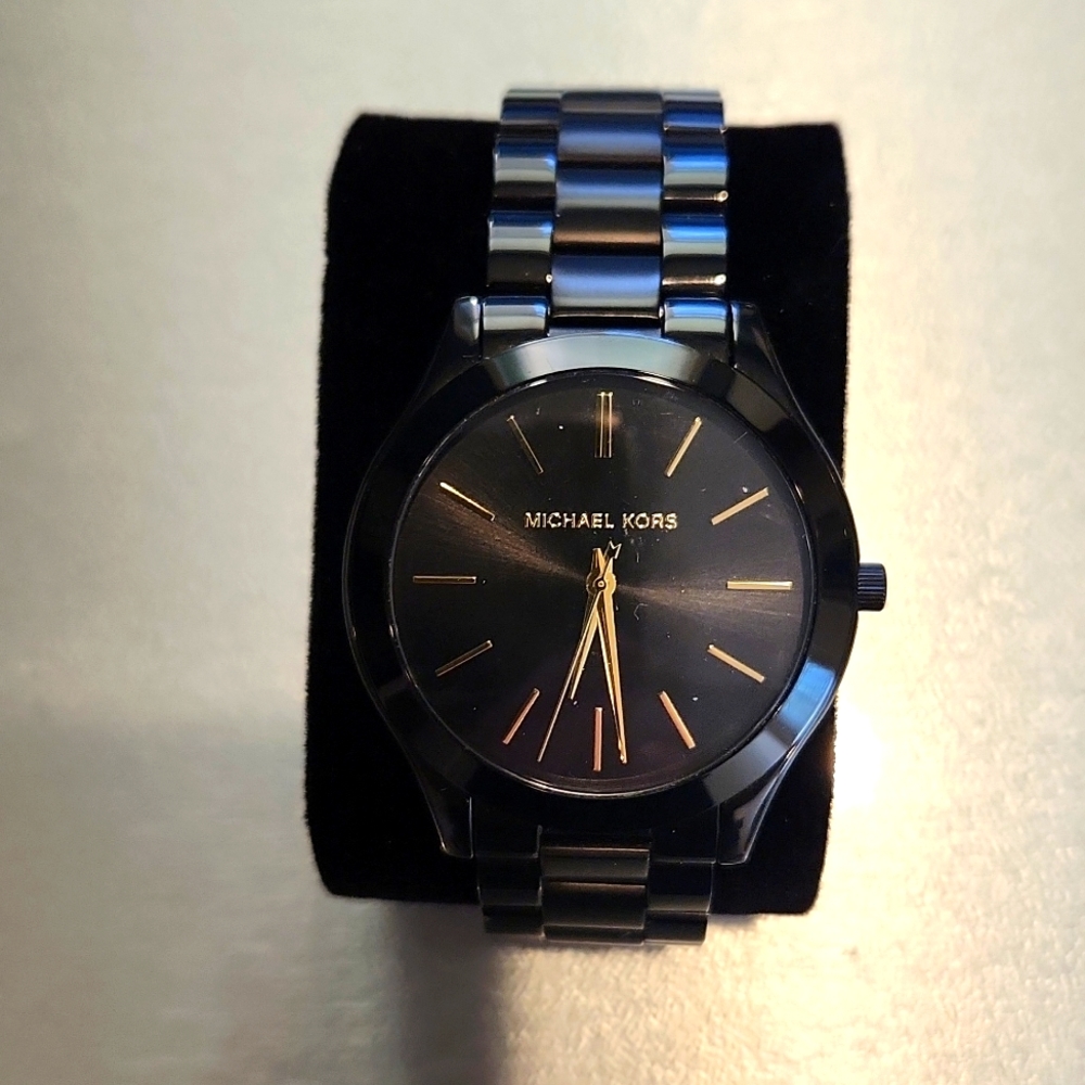 MICHAEL KORS WATCH, BLACK FACE, BLACK CERAMIC BAND, GOLD HOUR AND MINUTE HANDS.